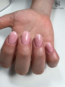 Manucure sur une main de type gel en couleur rose