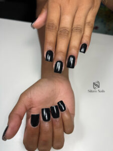 Manucure sur une main de couleur noir