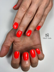 Manucure sur une main de couleur rouge