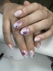 Manucure florale aquarelle, fleurs violettes sur ongles ronds, réalisée chez Sillam Nails à Villeurbanne