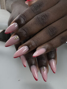 Manucure amande, pointe rouge et strass dorés, réalisée chez Sillam Nails à Villeurbanne