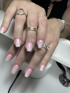 Détail d'une manucure française dégradée carrée élégante, blanc et rose