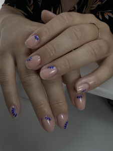 Ongles courts fleurs bleues, pose délicate et artistique